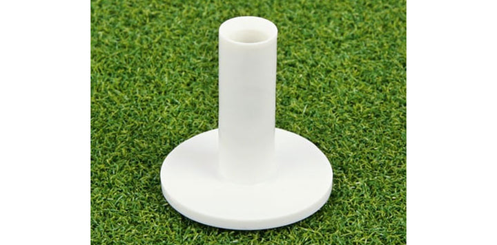 white rubber golf tee on top of the artificial turf of an Orlimar Residential Golf Mat