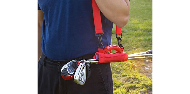 person carrying a red Orlimar Grab 'n Go Portable Golf Club Carrier with the shoulder strap with 3 golf clubs inside
