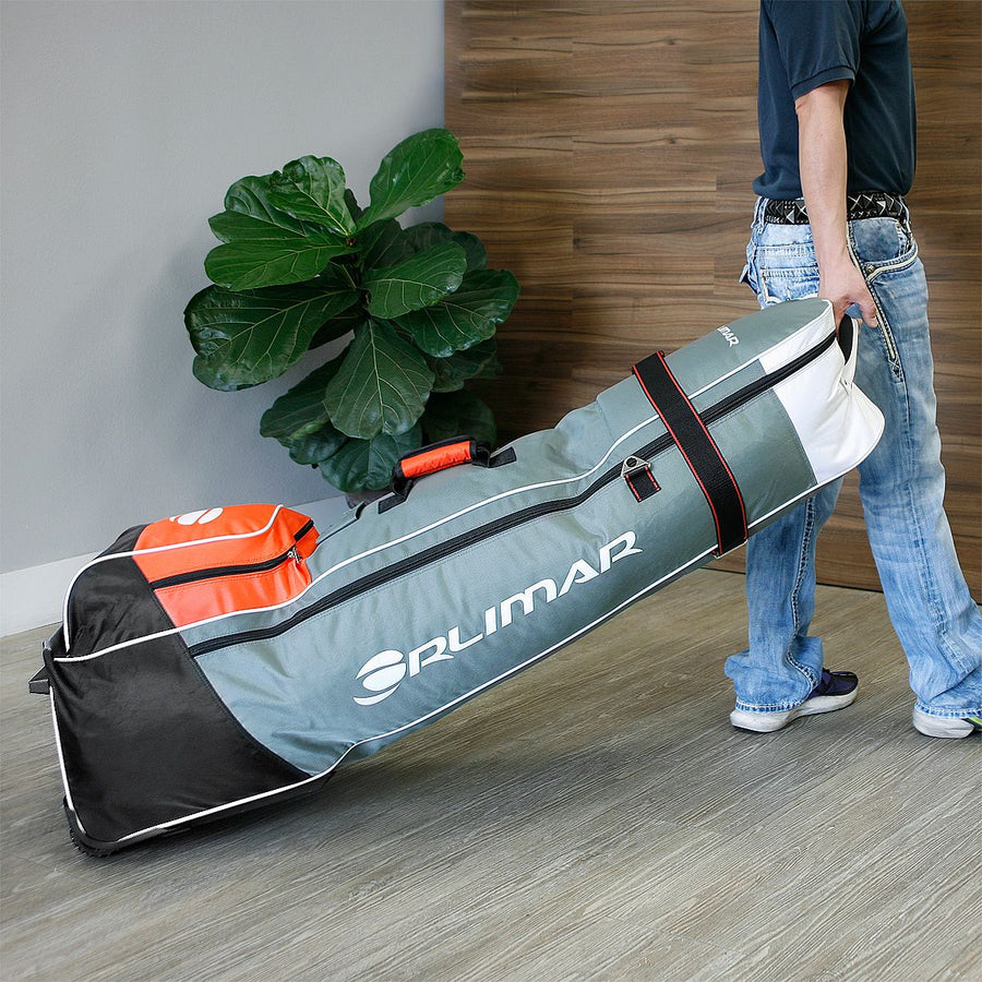 person pulling a Orlimar 1680D Super Duty Deluxe Wheeled Golf Travel Cover by top carry handle in a lobby