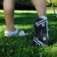 woman wearing a pair of ladies Orlimar Golf Sandals with Replaceable Spikes in the grass with right heel off the ground