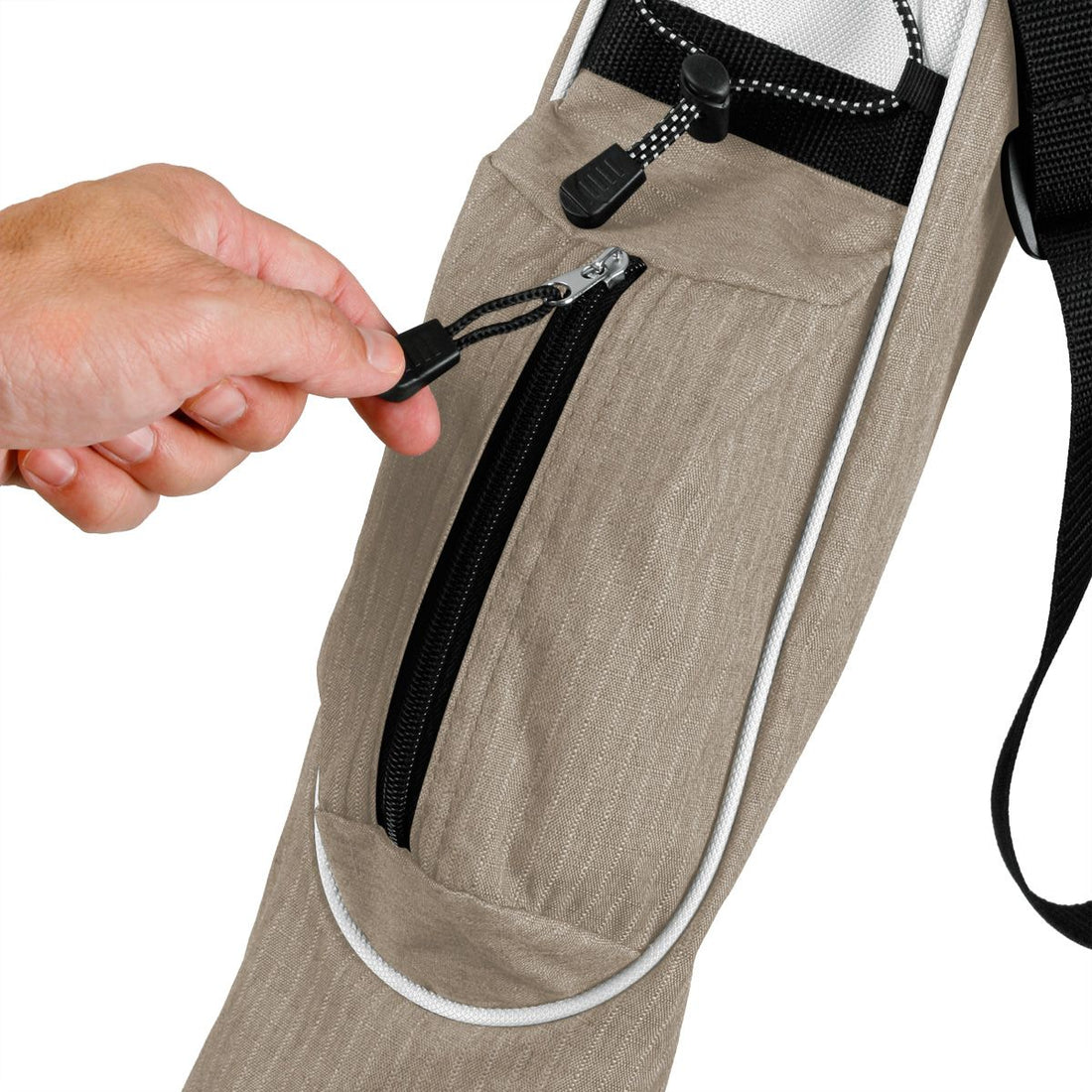 a person’s left hand the pulling zipper on the accessories pocket of a mocha brown Orlimar Pitch &