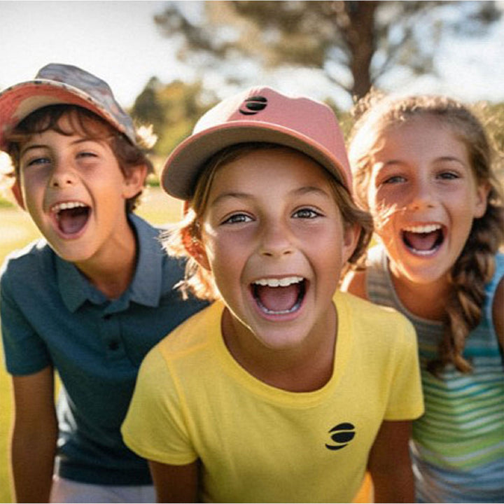 3 happy kids with middle girl wearing aan Orlimar logoed hat and yellow tee shirt