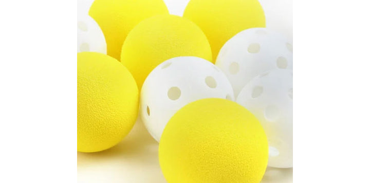up close view of 4 white perforated plstic golf balls and 4 solid yellow foam golf balls