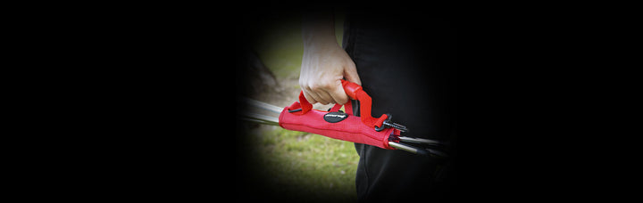 person carrying a red Orlimar Grab 'n Go Portable Golf Club Carrier by the handle with golf clubs inside
