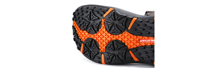 up close view of the black sole of an Orlimar Spikeless Golf Sandal with orange accent colors