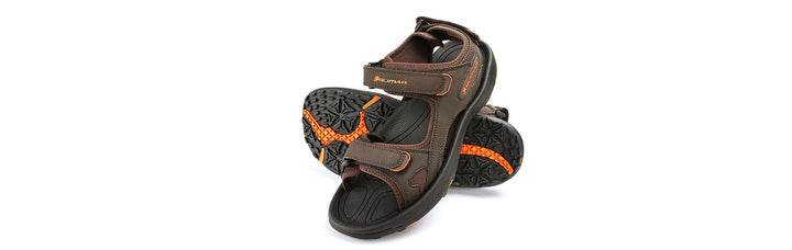 left brown Orlimar spikeless men's golf sandal leaning against the matching right sandal showing the sole
