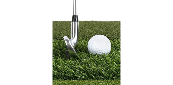 golf iron behind a white golf ball on the simulated grass rough going against the grain on an Orlimar Triple Surface Golf Hitting Mat
